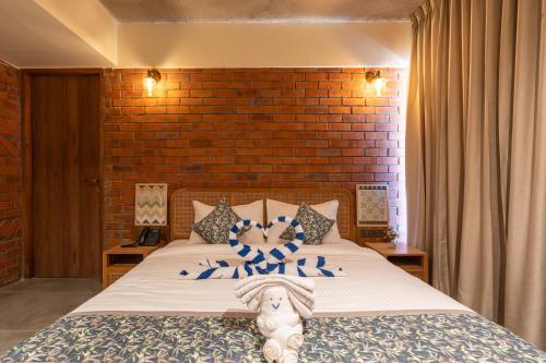 a bedroom with a bed and a brick wall at The Foresta Resort ,Mulshi in Paud