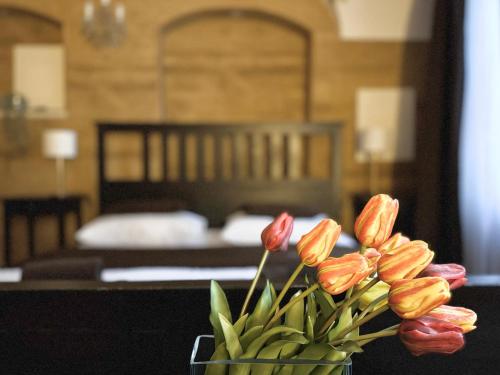 un jarrón de flores sobre una mesa en un dormitorio en Unique Prague Apartment, en Praga