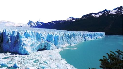 a large glacier in front of a body of water at Casa YASA con parque privado y parrilla in El Calafate