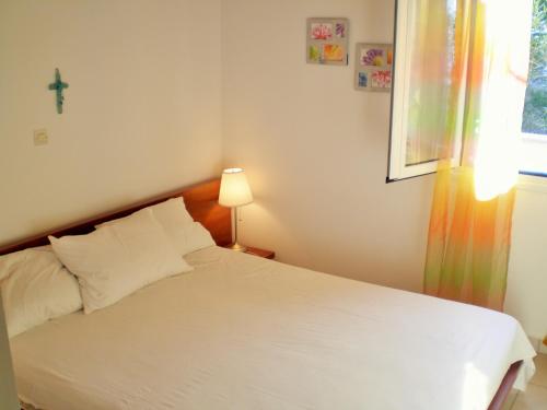 ペレカスにあるMENIGOS RESORT - Διαμέρισμα Αριθμός 168のベッドルーム1室(壁にクロス付きの白いベッド1台付)