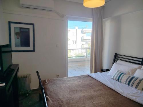 a bedroom with a bed and a large window at Emily's luxury apartment in Vari
