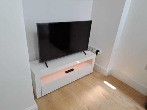 a flat screen tv sitting on top of a white cabinet at AcLand Lodge Dovercourt West in Harwich