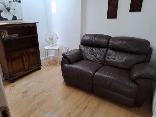 a brown leather couch in a living room at AcLand Lodge Dovercourt West in Harwich