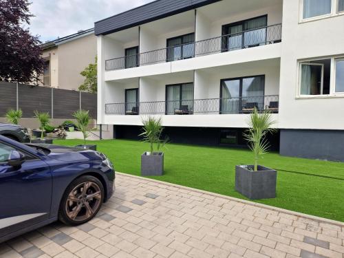 a car parked in front of a building with palm trees at Hotel am Kurpark in Bad Wimpfen
