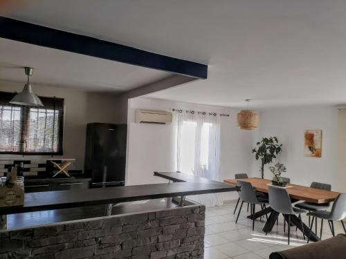 une cuisine et une salle à manger avec une table et des chaises dans l'établissement Maison 100m2 plain pied 3 chambres piscine 2 places Parking, à Gigean