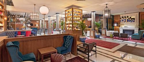 a lobby of a hotel with a bar and chairs at Boutique Hotel H10 Villa de la Reina in Madrid