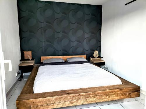 une chambre avec un grand lit avec un mur végétal dans l'établissement Maison 100m2 plain pied 3 chambres piscine 2 places Parking, à Gigean