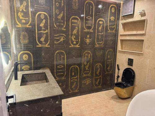 a bathroom with a wall covered in hieroglyphics at Rafif hotel in Cairo