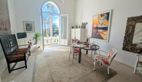 un salon avec une table et des chaises et une fenêtre dans l'établissement Ref MAURESQUE by Palmes d Or Properties, au Golfe-Juan