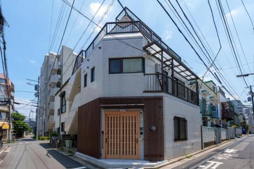 a building with a wooden door on a street at 楽逸グループ 池袋瑞月苑3F 111Tc in Tokyo