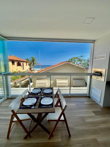 a room with a table and chairs on a balcony at Praia de Piratininga Apartamento Vista Para o Mar in Niterói