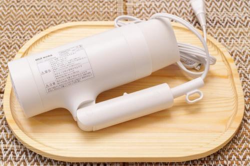 a white blow dryer on a wooden cutting board at 楽逸グループ 池袋瑞月苑3F 111Tc in Tokyo
