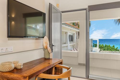 a dining room with a table and a view of the ocean at Boutique Hotel Bougainvillea in Kralendijk
