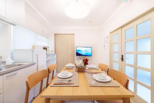 a dining room with a wooden table and chairs at 楽逸グループ 池袋瑞月苑3F 111Tc in Tokyo