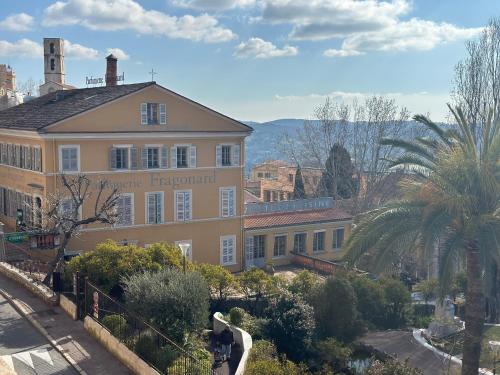 un grand bâtiment avec un palmier devant dans l'établissement 3 Pièces Vue Mer à proximité des Parfumeries, à Grasse