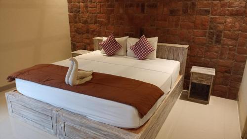 - une chambre avec un grand lit recouvert d'un cygne dans l'établissement De Sudi Bungalows, à Pemuteran