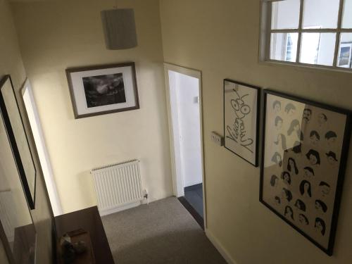 a hallway with paintings on the wall and a door at Arts House centre of Harwich Harbour in Harwich