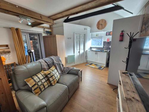 a living room with a couch and a kitchen at Sied Yr Ardd in Ystradgynlais