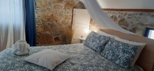 ein Schlafzimmer mit einem Bett mit Baldachin und Kissen in der Unterkunft Casinha Nº461 in Vila Praia de Âncora