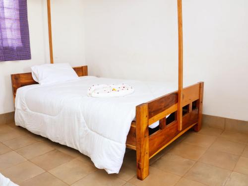 a bedroom with a bed with a white blanket on it at STC.SAFARI LODGE in Oldeani