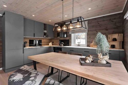 a kitchen with a wooden table and a dining room at New big cabin near the city centre! in Røros