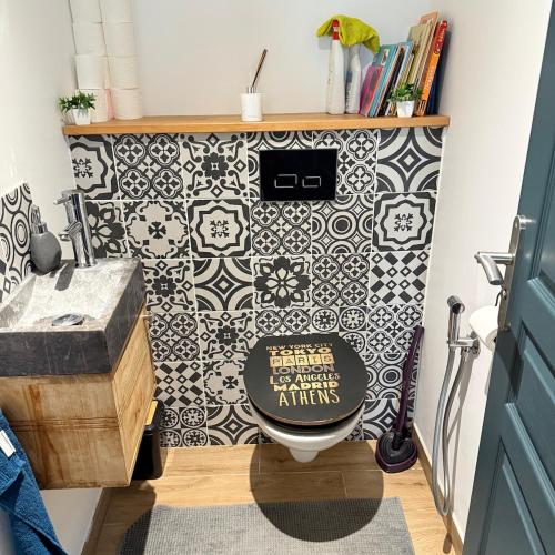 La salle de bains est pourvue de toilettes et de carrelage noir et blanc. dans l'établissement Jolie villa Bali-style, à Marseille