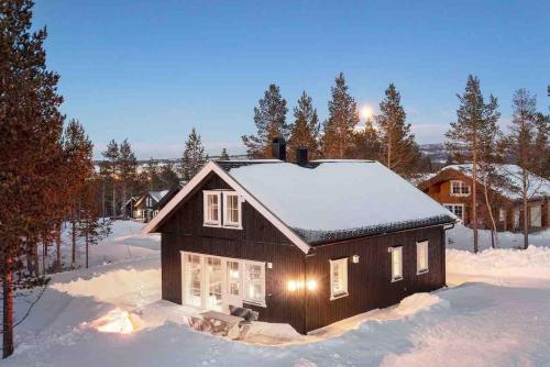 a small house with snow on the roof at New big cabin near the city centre! in Røros