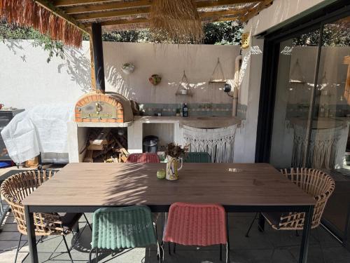 une table et des chaises en bois sur une terrasse dans l'établissement Jolie villa Bali-style, à Marseille