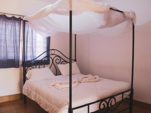 a bedroom with a canopy bed with white sheets at STC.SAFARI LODGE in Oldeani