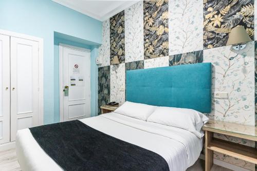 a bedroom with a bed and a blue headboard at Hotel Mexico in Madrid