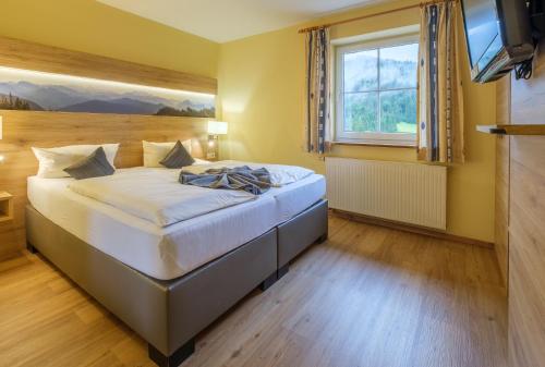 a bedroom with a bed and a television in it at Gasthof Schwabenhof in Balderschwang