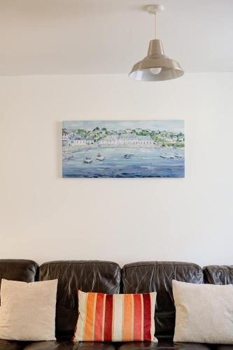 a couch in a living room with a painting on the wall at Juniper House in Harwich