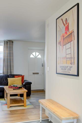 a living room with a picture on the wall and a table at Juniper House in Harwich