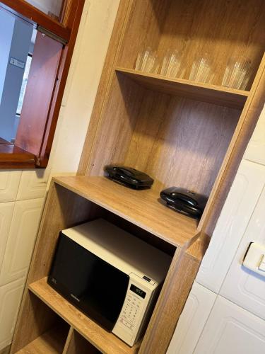 a cabinet with a microwave and a phone in it at Hostelfc Marly in Bogotá
