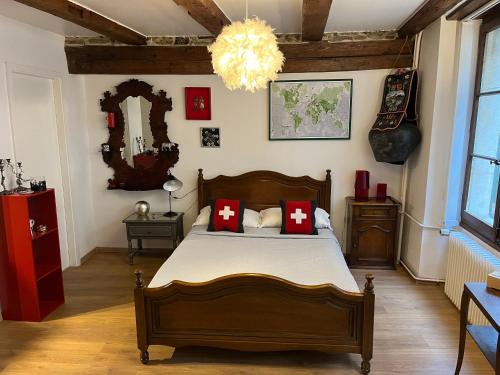 a bedroom with a bed with red pillows and a chandelier at Studio au cœur de la ville in Neuchâtel