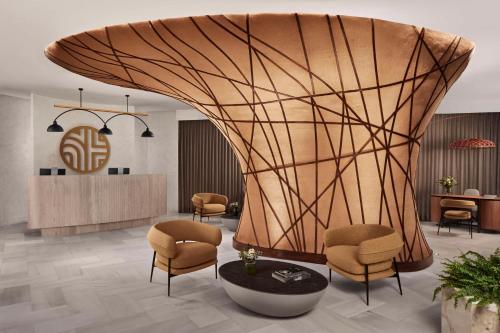 a lobby with a round table and chairs at NH Collection Palacio de Córdoba in Córdoba