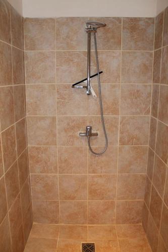 une douche avec pommeau de douche dans une salle de bain dans l'établissement A Charming Countryside Retreat Le Mas No 14, à Ayen