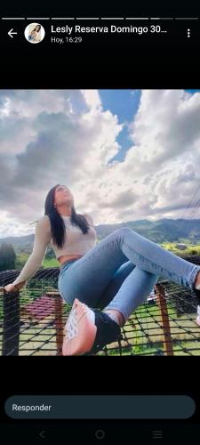 a woman sitting on top of a fence at Glamping El Ocaso in Zipaquirá