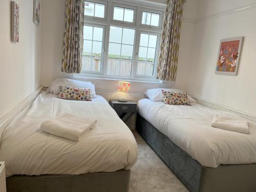 two twin beds in a room with a window at Oak View in Saint Osyth