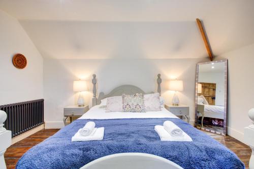 Un dormitorio con una cama grande con toallas. en Charming 4-Bed Countryside Retreat with Parking, en Batheaston