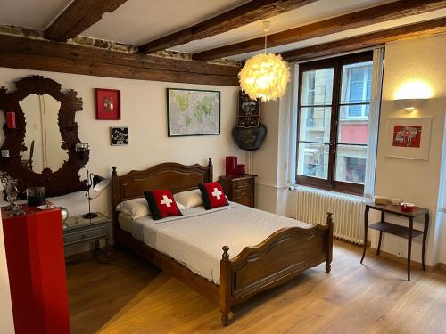 a bedroom with a bed with red pillows and a mirror at Studio au cœur de la ville in Neuchâtel