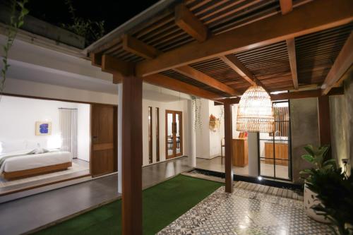 1 dormitorio con cama y alfombra verde en Lorn Villa, en Nusa Penida