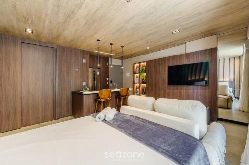 a bedroom with a large white bed and a kitchen at NWTs - Estúdios em Prédio com Vista Mar in Maceió