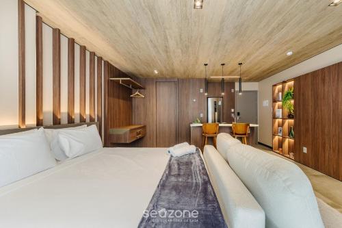 a bedroom with a large white bed and wooden ceilings at NWTs - Estúdios em Prédio com Vista Mar in Maceió
