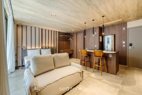 a bedroom with a bed and a kitchen with a bar at NWTs - Estúdios em Prédio com Vista Mar in Maceió