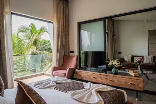 a bedroom with a bed and a large window at Vilmaris Luxury Villas in Saligao