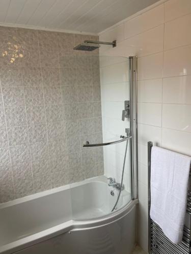 a bathroom with a bath tub and a towel at Sea Breeze in Harwich