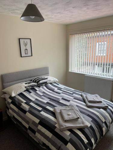 a bedroom with a bed with towels on it at Sea Breeze in Harwich