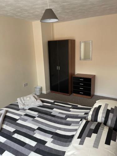 a bedroom with a large bed and a dresser at Sea Breeze in Harwich