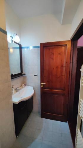 a bathroom with a sink and a wooden door at Dimora Acqua del Fico in Castellabate